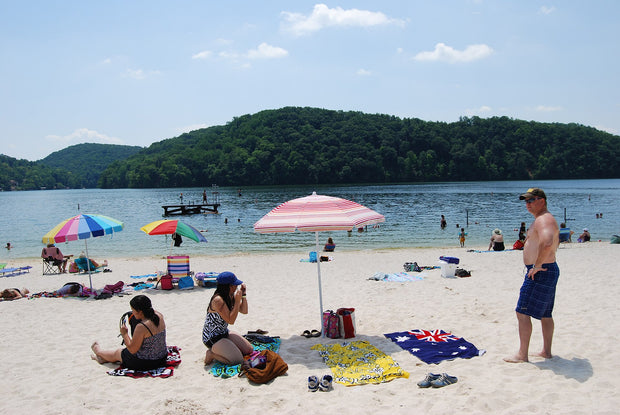 Sandy beach and blue water at Claytor Lake State Park, Virginia, surrounded by wooded Blue Ridge shoreline