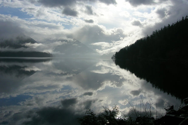 Lake Crescent in Olympic National Park, Washington, glassy blue water reflecting clouds and forested mountains